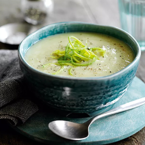 Leek and potato Slimming World soup in turquoise bowl and plate with a silver spoon on the side